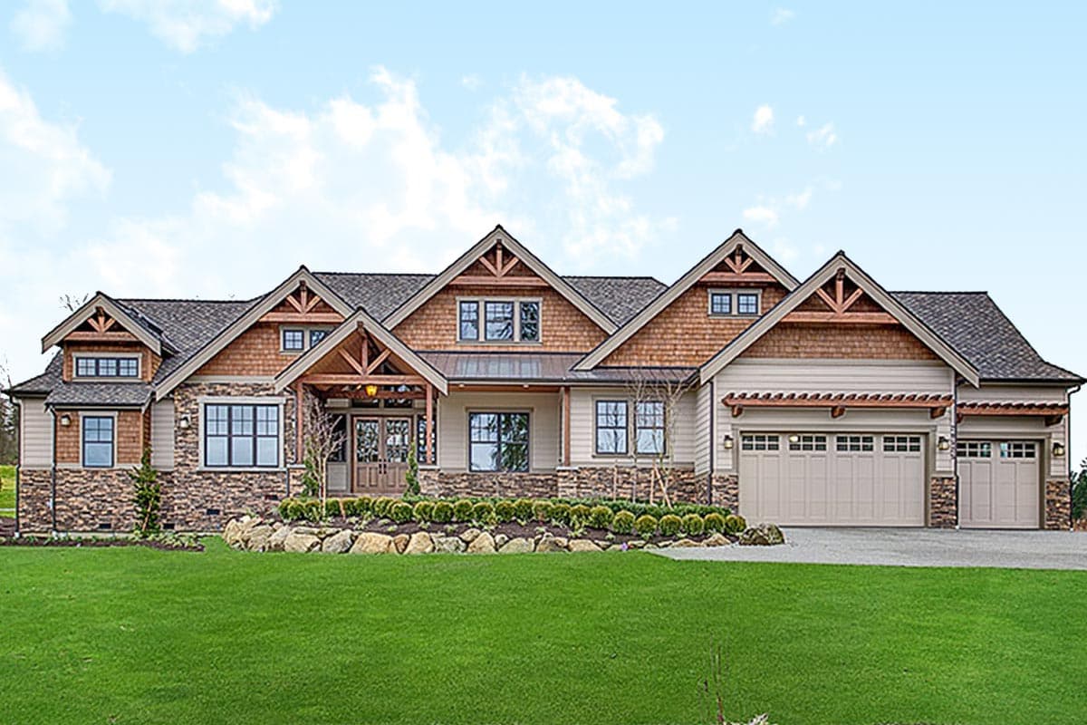 Craftsman house plan exterior with multiple gables, stone and wood siding, a covered entry, and a three-car garage.