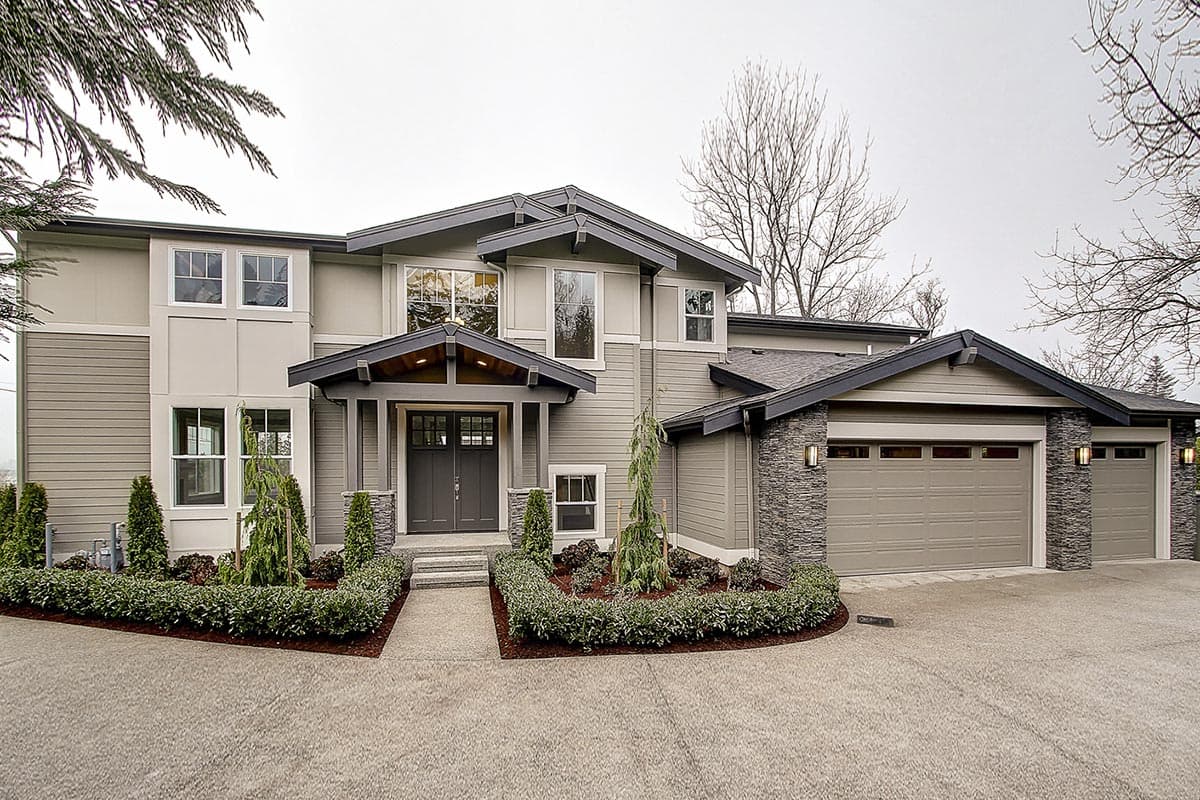 Modern house plan exterior with prominent gables, stone accents, covered entry, and a three-car garage.