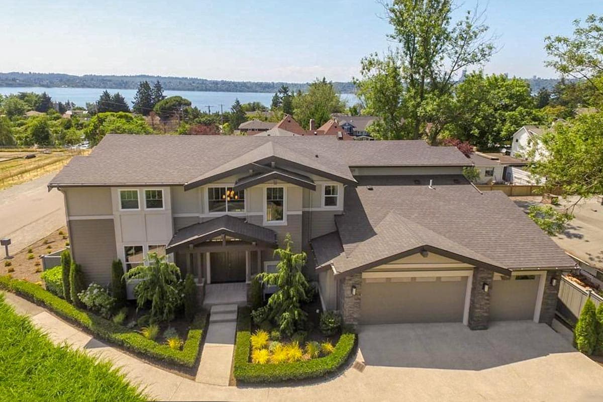 House plan exterior: two-story home with a covered entry porch, multiple gables, and a three-car garage.