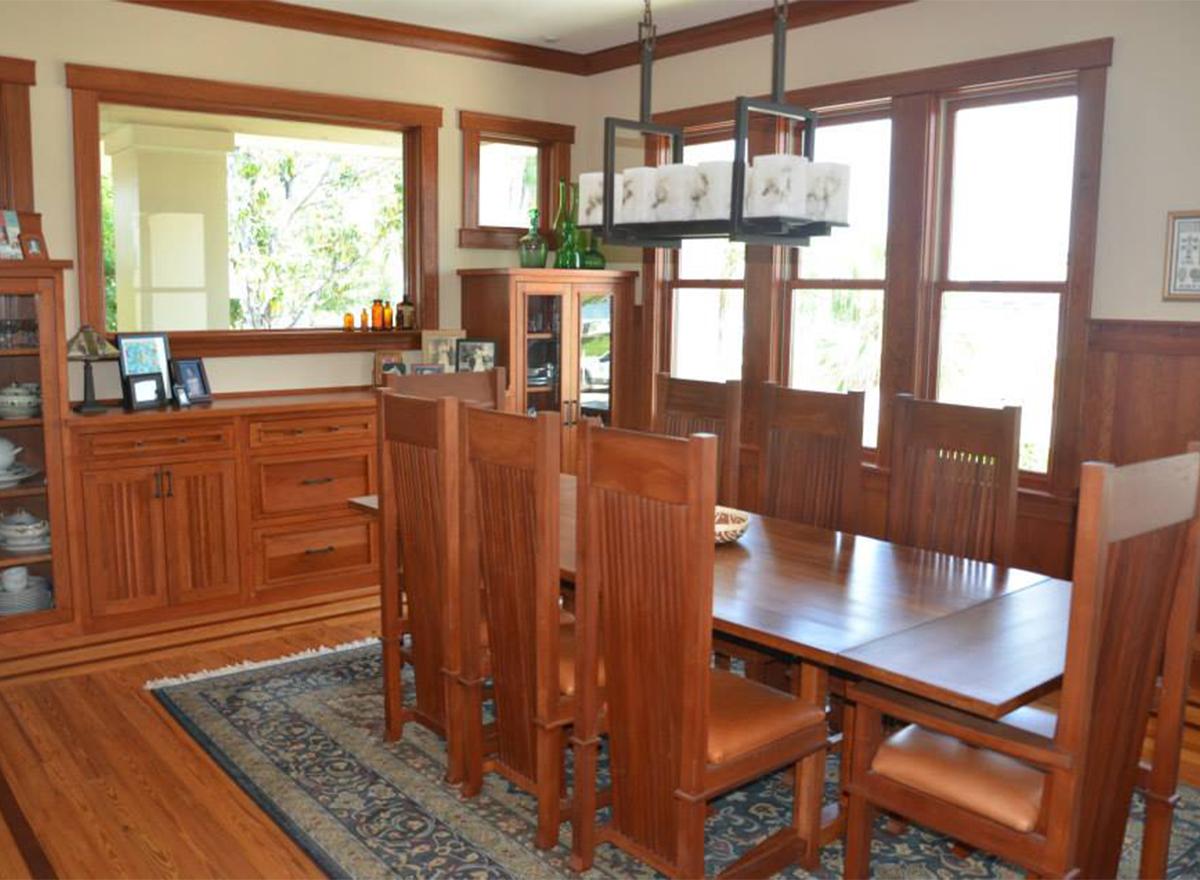 Dining room with wood dining table, chairs, built-in buffet, glass-front china cabinet, and patterned rug.