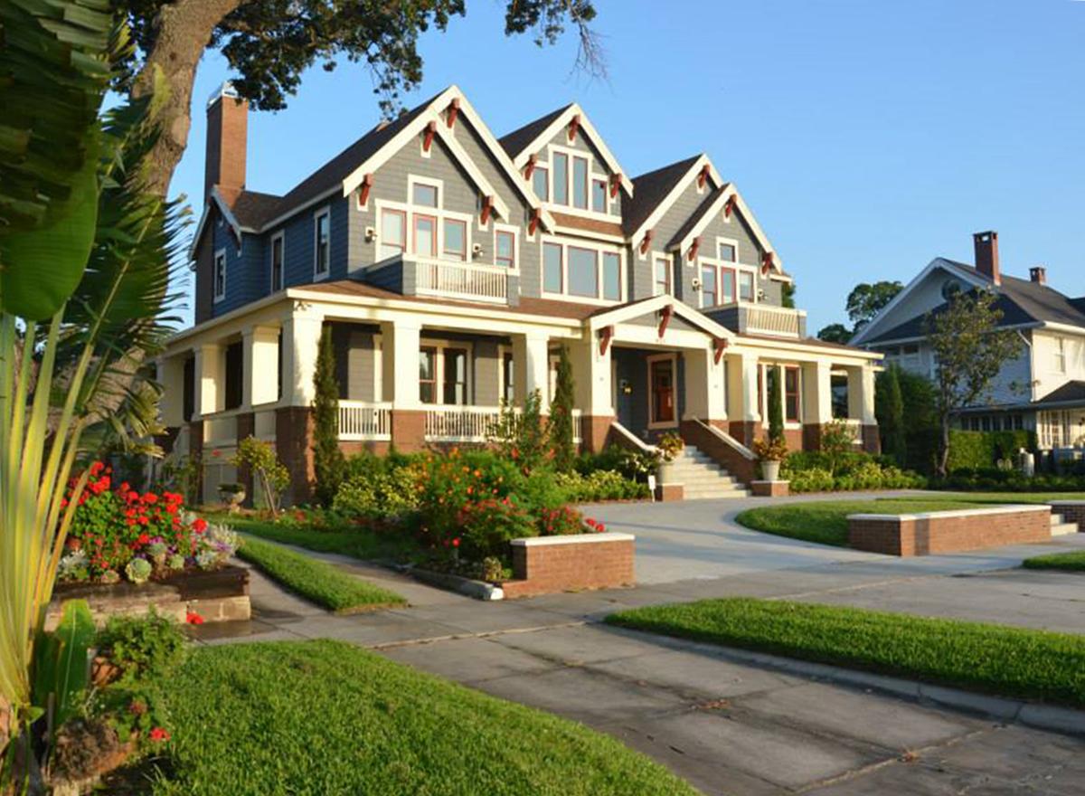 House plan exterior: Two-story home with a wrap-around porch, multiple gables, and decorative eaves.