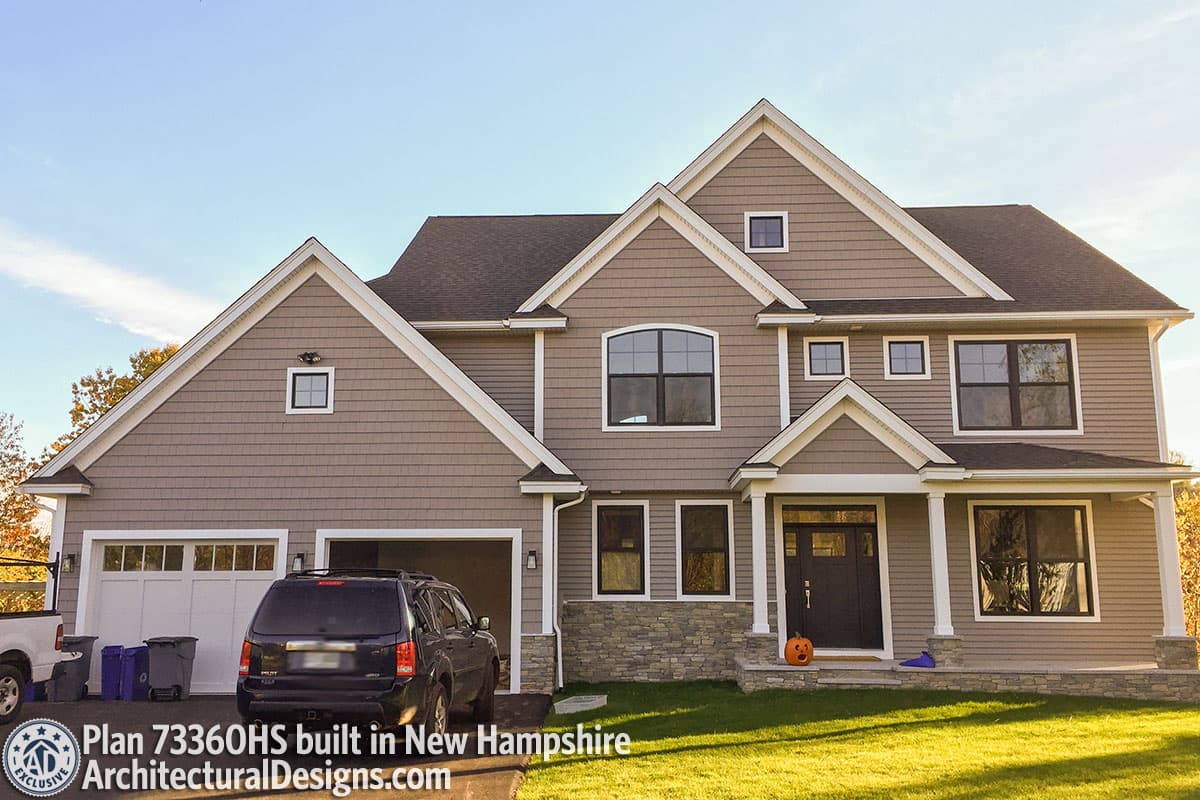 House plan exterior: Two-story dwelling with double garage, multiple gables, stone foundation accents, and covered entry porch.