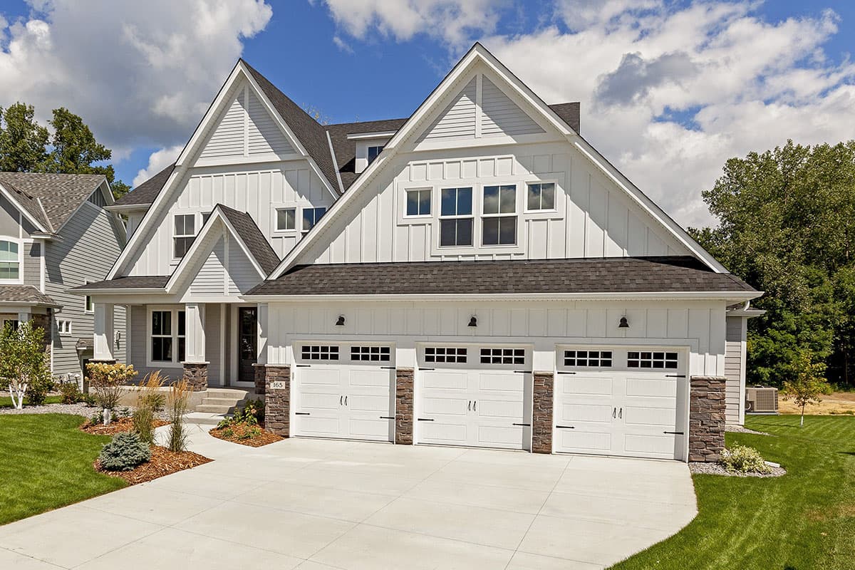 House plan exterior: Modern Farmhouse style with three-car garage, gables, and board and batten siding.