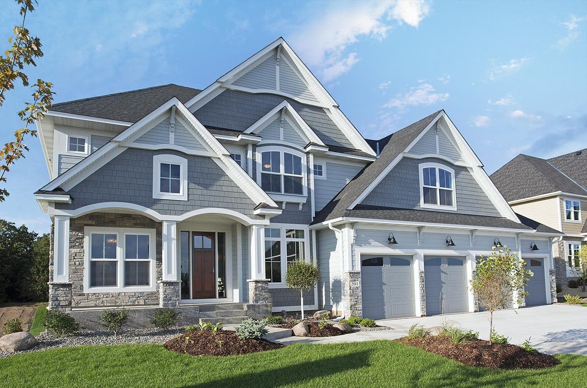 House plan exterior with gabled roofs, arched entry, stone accents, and a three-car garage.