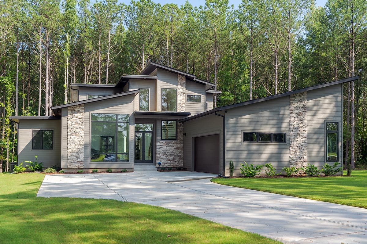 Modern house plan exterior with stacked stone accents, a two-car garage, and a prominent sloped roofline.