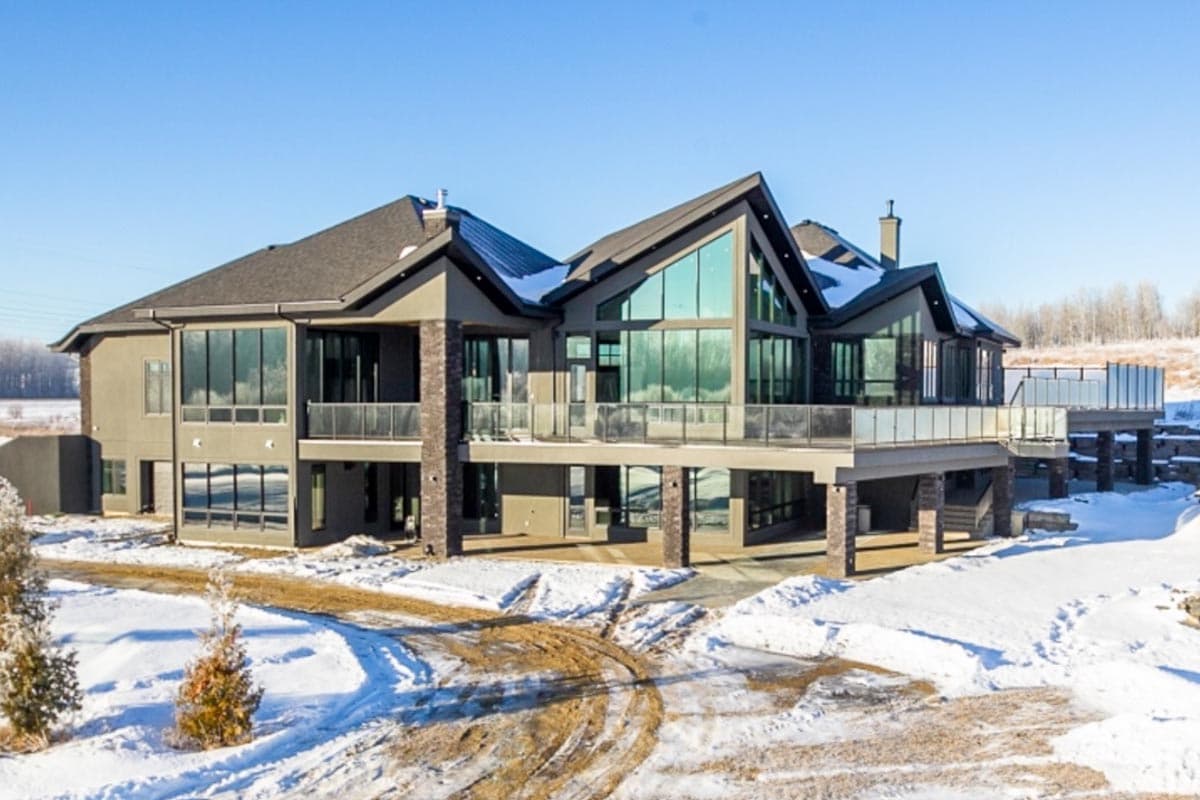 House plan exterior: Modern style, two stories, large windows, multiple balconies, and peaked rooflines.