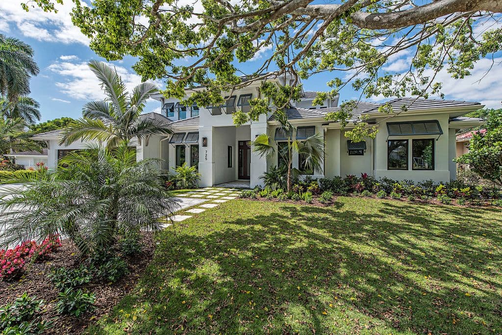 Modern two-story house plan exterior with a covered entry, flat roof, and decorative shutters.