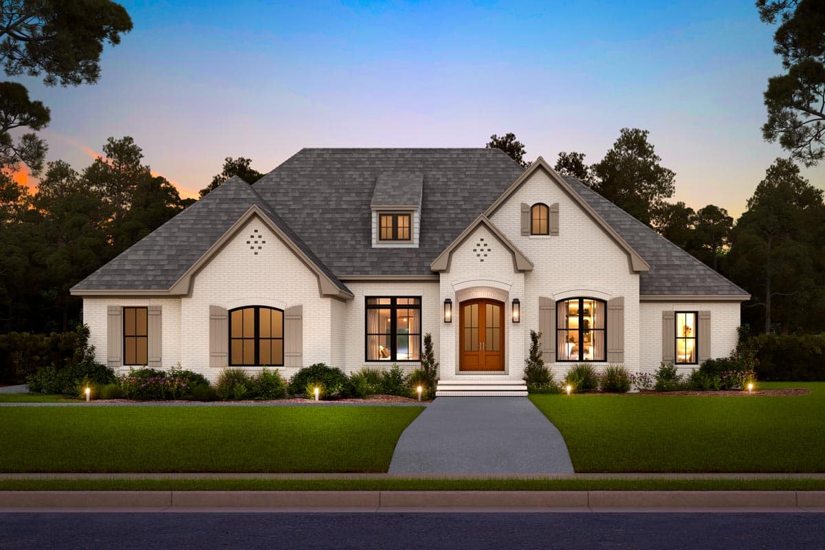 House plan exterior: One-and-a-half story with white brick, arched windows, dormers, and a prominent gabled entrance.