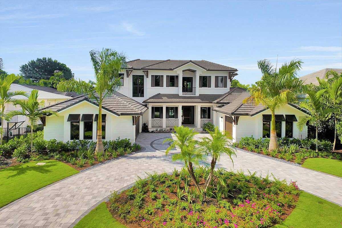 House plan exterior. Two-story, white stucco house with a tile roof. Features include gables, multiple dormers, and an attached garage.