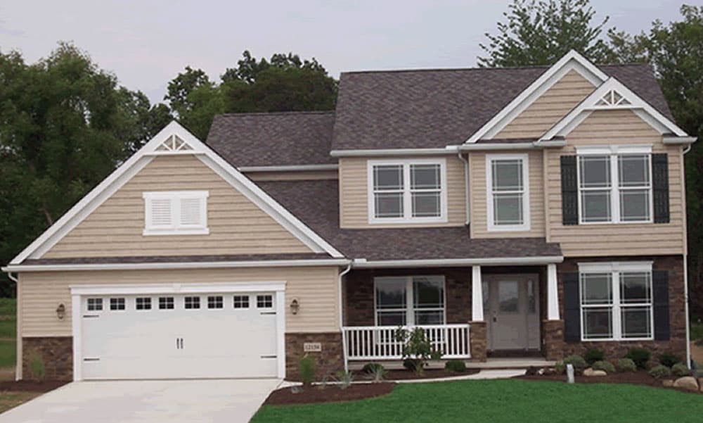 Two-story house plan exterior with a gable dormer, two-car garage, covered porch, and stone accents.