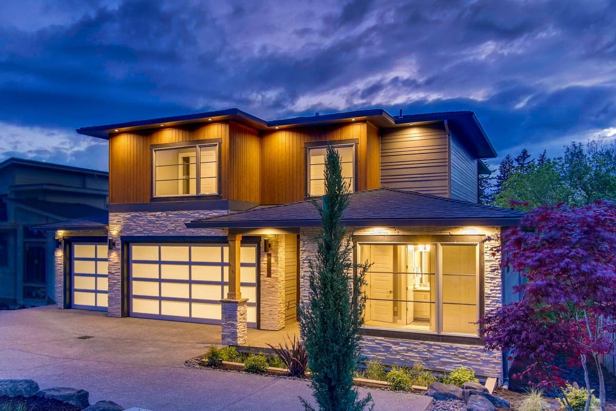 House plan exterior with two stories. Features include a Craftsman style, stone facade, covered entry, and attached garage with glass panels.