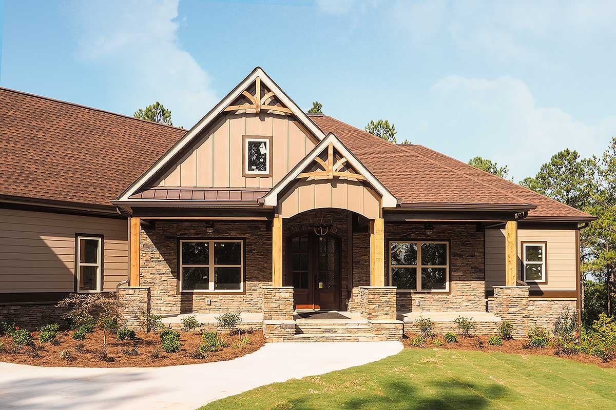 Craftsman style house plan exterior with stone and siding, covered porch with wood beams, and prominent gables.