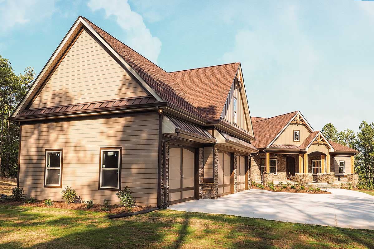 House plan exterior with triple garage, stone accents, and covered entry with exposed beams.
