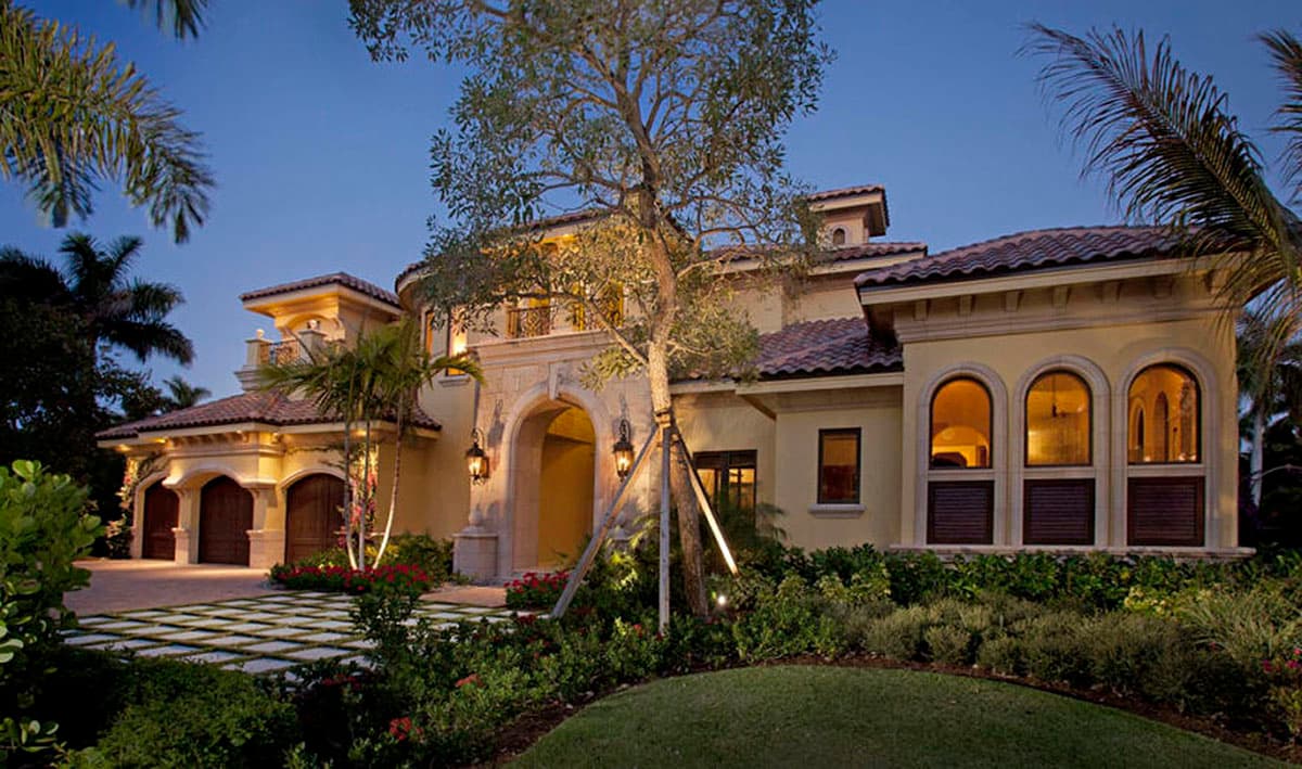 House plan exterior with Mediterranean style, two stories, arched entry, barrel tile roof, and arched windows.