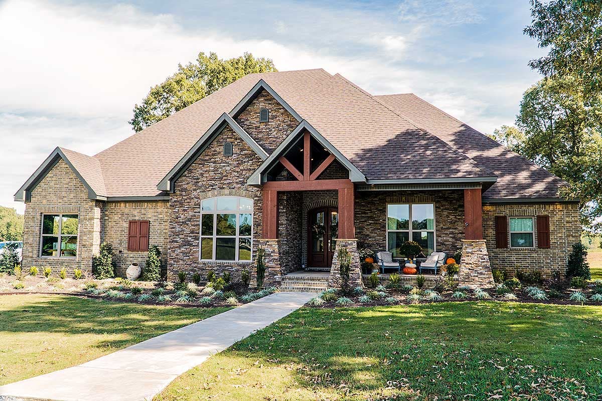 House plan exterior: Ranch style, stone and brick facade, covered porch with wood beams, multiple gables.