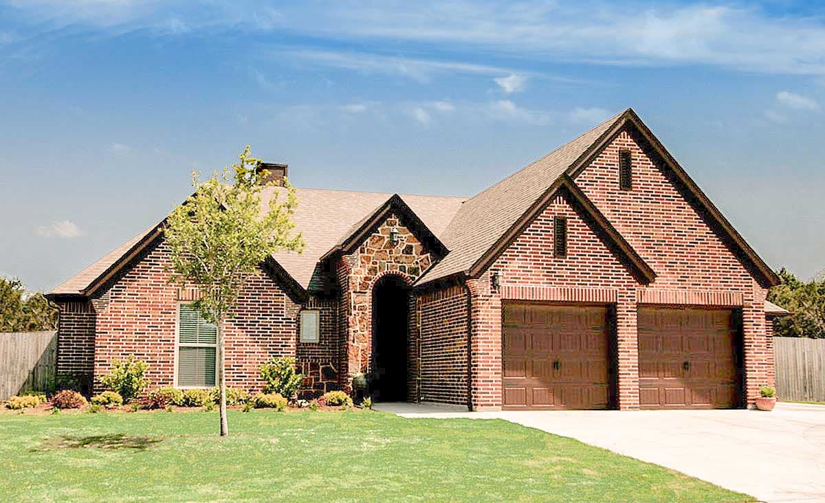 House plan exterior. One-story brick home with gabled roof, stone archway over front entrance, and two-car garage with gabled roof.