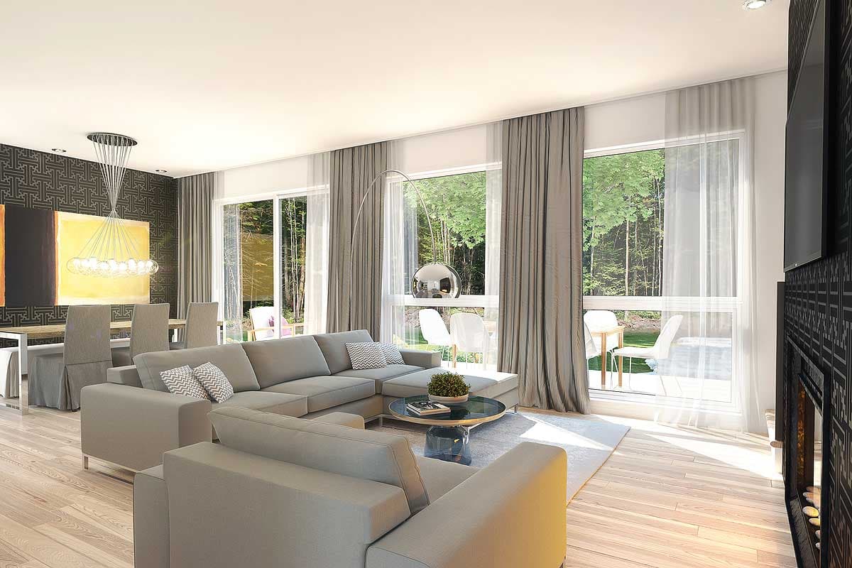 Open concept living and dining area with large windows, a sectional sofa, and a fireplace.