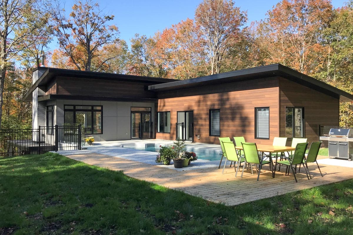 Modern house plan exterior with wood and stone siding, a flat roof, and a swimming pool.
