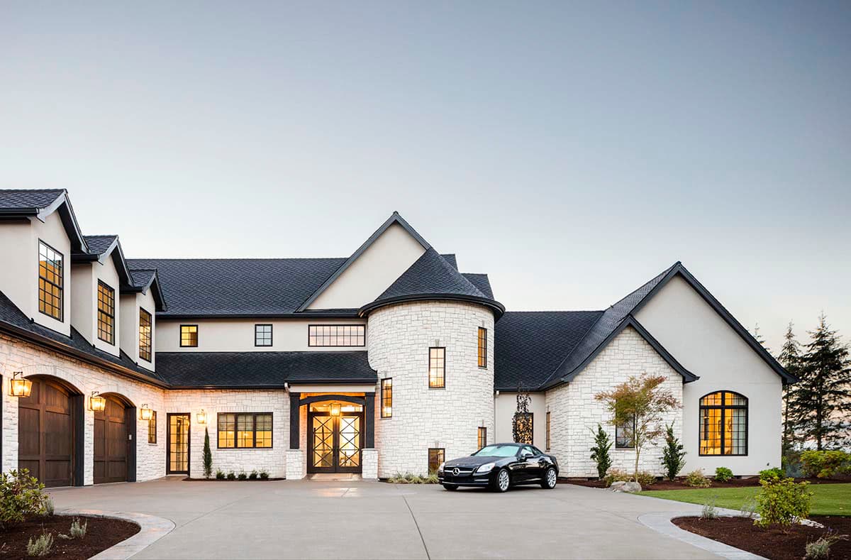 House plan exterior: Two-story Modern style with white stone facade, turrets, arched garages, gabled rooflines, and decorative entry.
