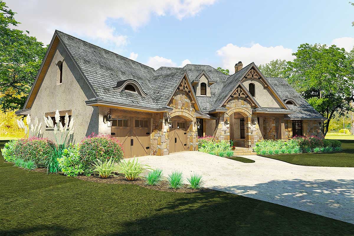 House plan exterior: Tudor style with stone accents, three-car garage, and arched entryways.