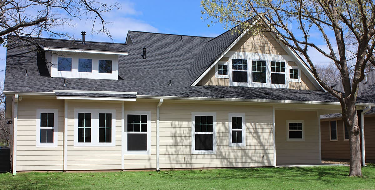 House plan exterior: Gable roof, dormers with multiple windows, and siding.