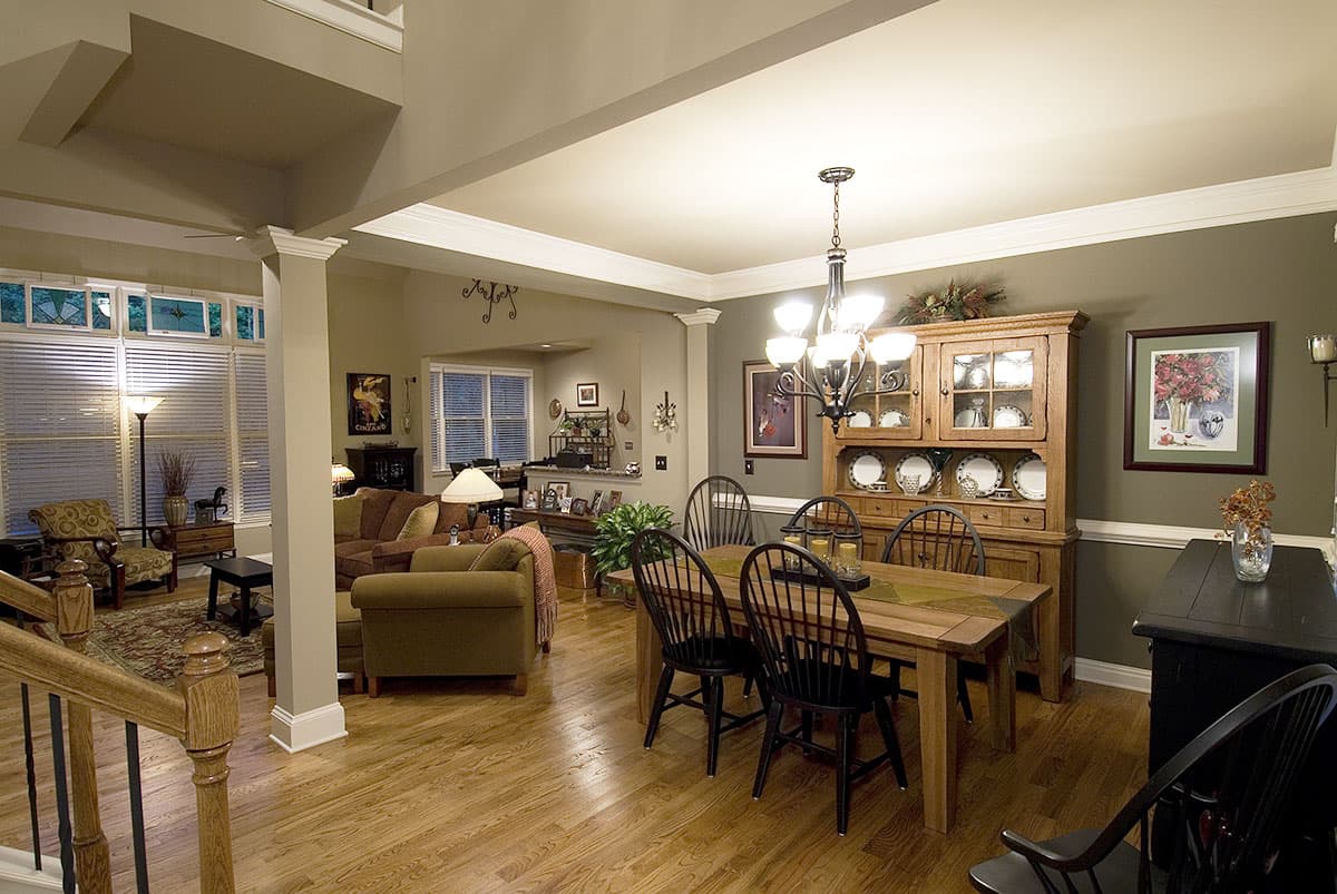 Open-concept living and dining area with wood floors, a large hutch, and a chandelier.