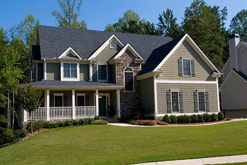 House plan exterior. Two-story Craftsman home with a front porch, multiple gables, stone accents, and a dark roofline.