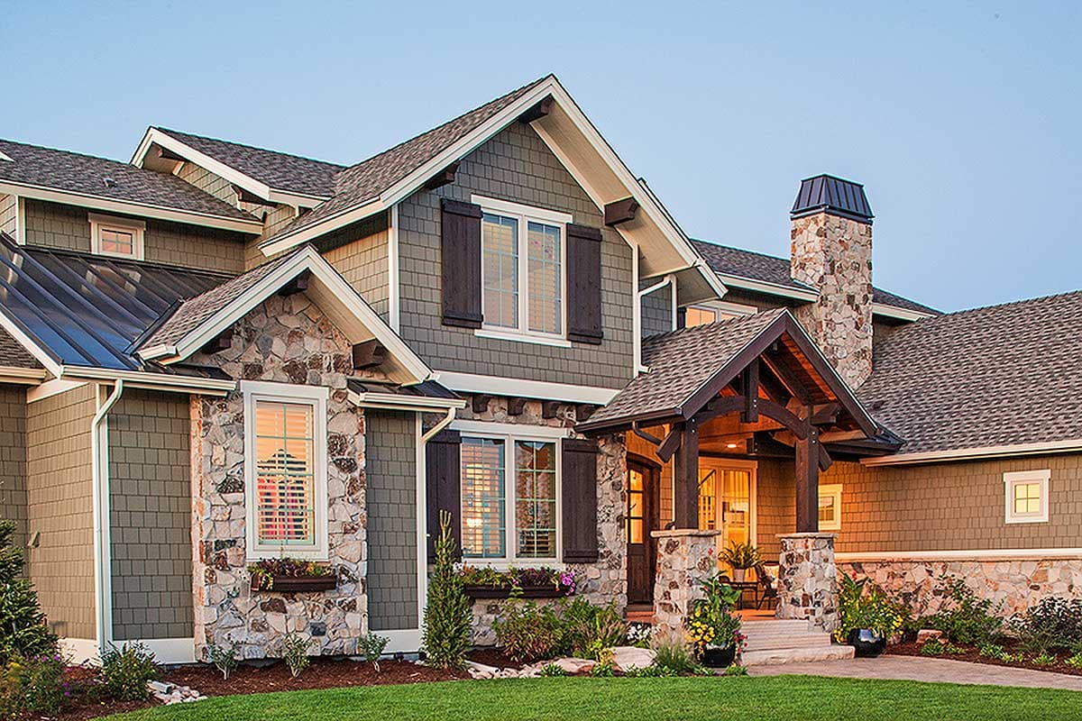 House plan exterior with stone accents, multiple gables, covered porch with exposed beams, and a prominent stone chimney.