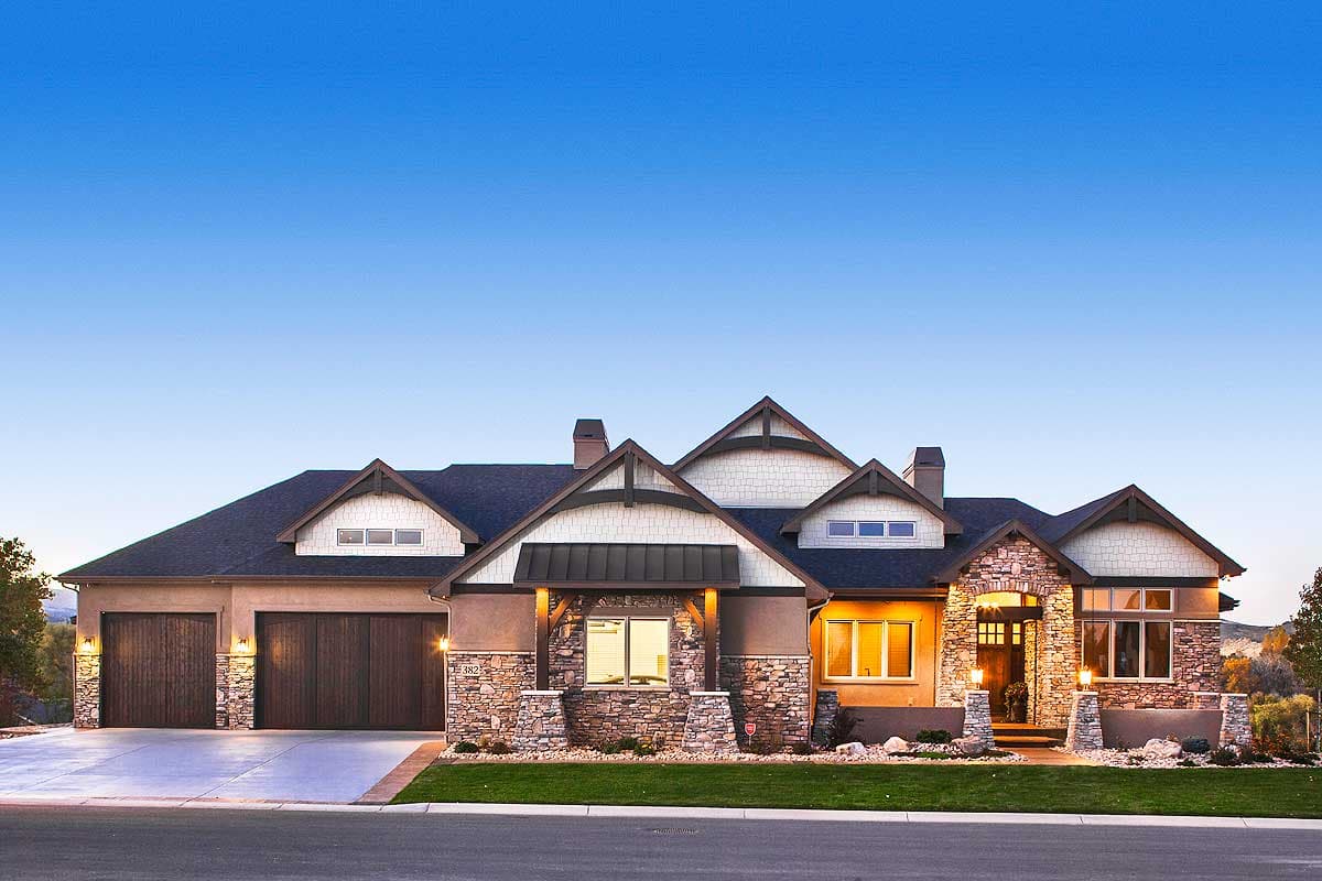 House plan exterior. Craftsman style with stone accents, multiple gables, and a front-entry portico. Features attached garage and dormers.