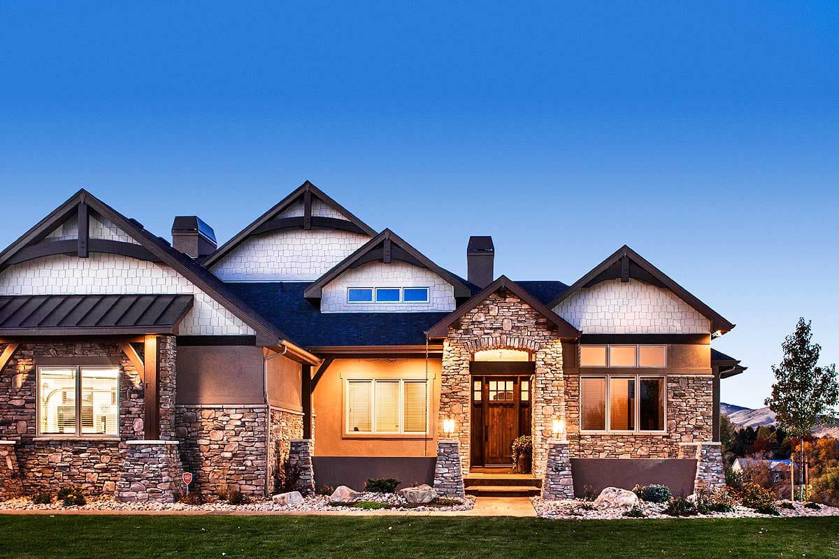 House plan exterior, Mountain Rustic style, with stone accents, prominent gables, and a covered entry porch.