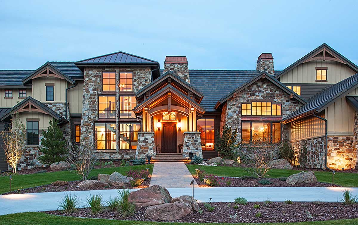 Mountain style house plan exterior with stone facade, multiple gables, and large windows.