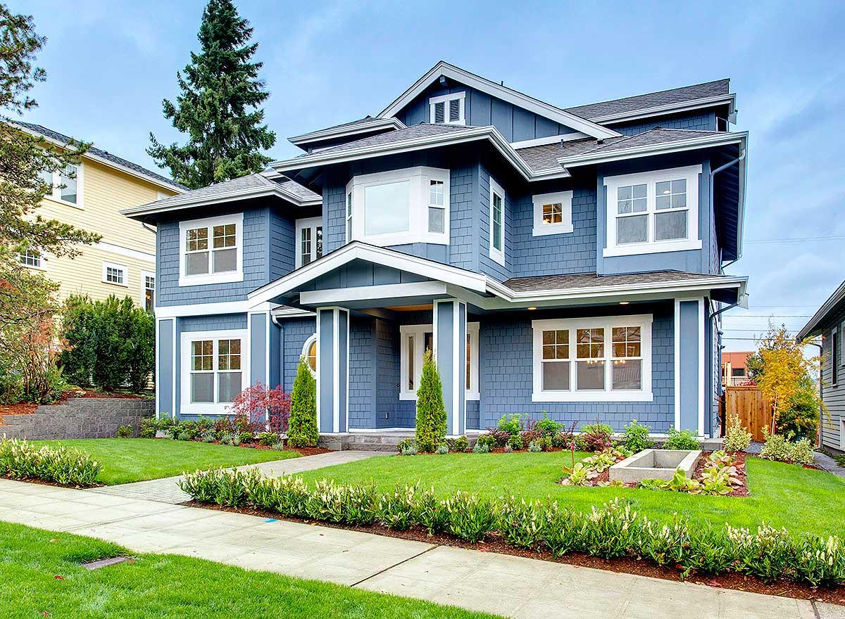 House plan exterior view of a two-story Craftsman home. Features include a front porch, gabled roof, dormers, and multiple windows.