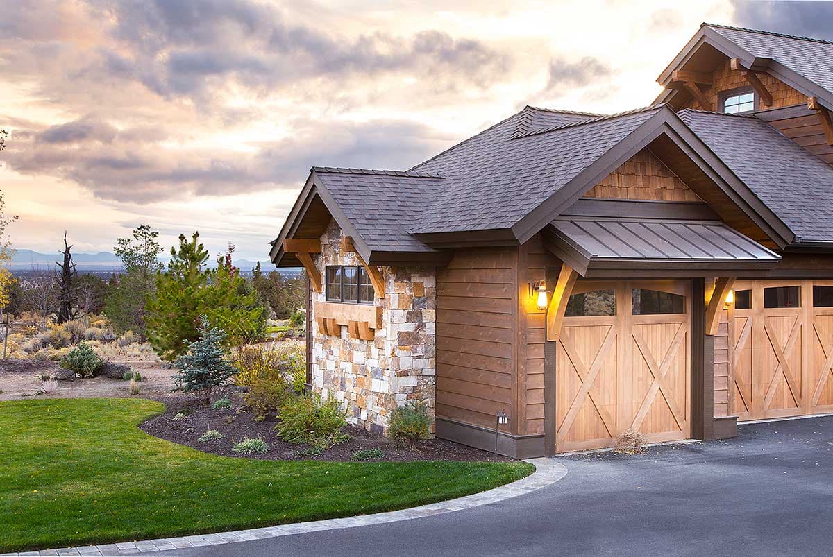 House plan exterior shows a Craftsman style home with stone and wood siding, gabled rooflines, and a three-car garage.