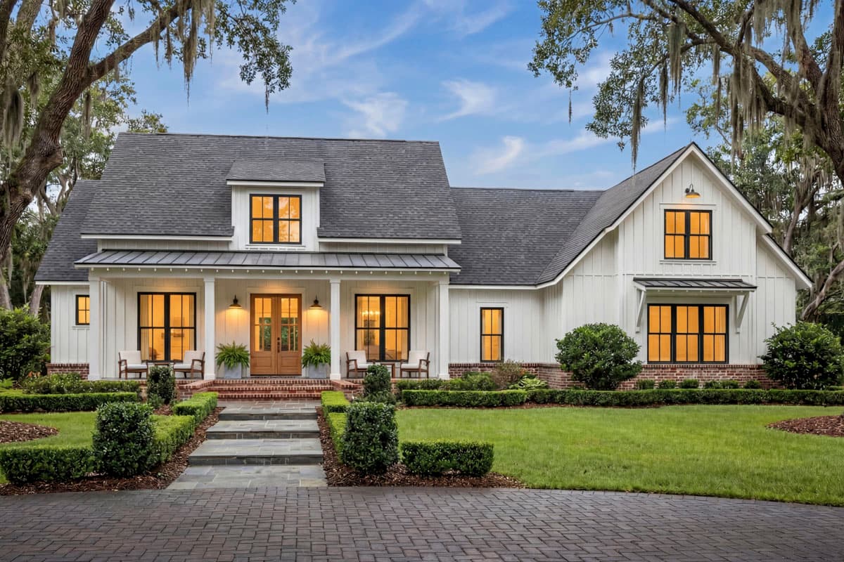 Modern farmhouse house plan exterior with a prominent gabled dormer, board and batten siding, metal roof porch, and double front doors.
