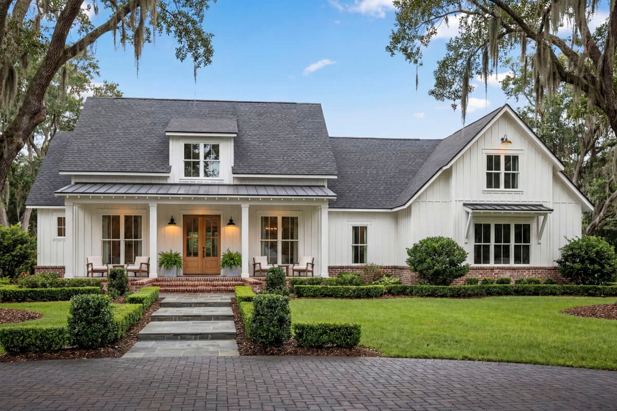 Modern farmhouse house plan exterior with white board-and-batten siding, metal roof porch, dormer, and gables.