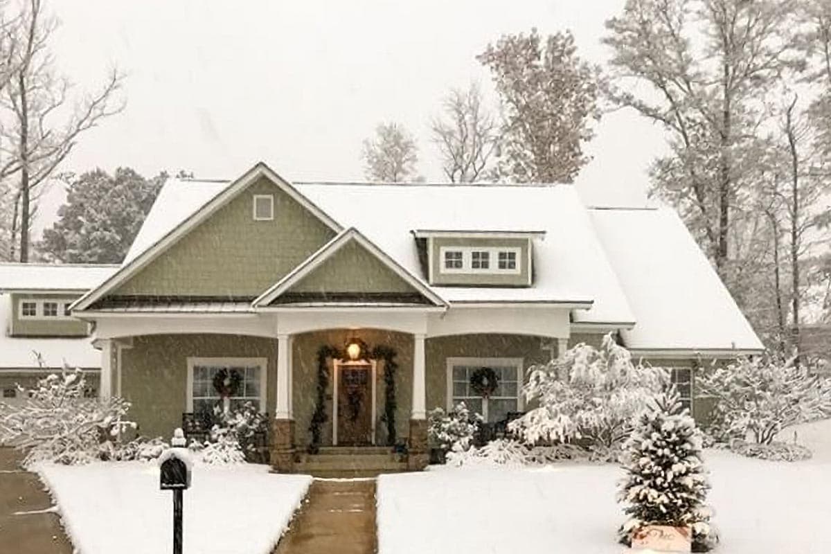 Craftsman-style house plan exterior with a covered porch, gables, dormer window, and winter snow.