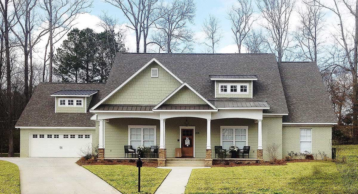 House plan exterior featuring a covered porch, dormer windows, gabled roofs, and a side-entry garage.