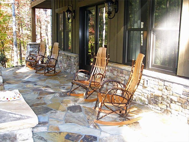 House plan exterior featuring a covered porch with flagstone flooring and rocking chairs.