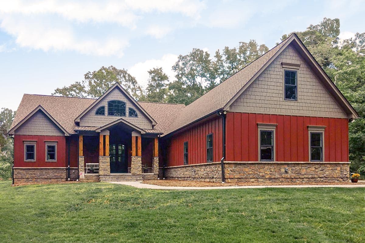 House plan exterior with Craftsman influences. Features include gabled rooflines, a covered porch, and stone accents. One-story home with dormer.