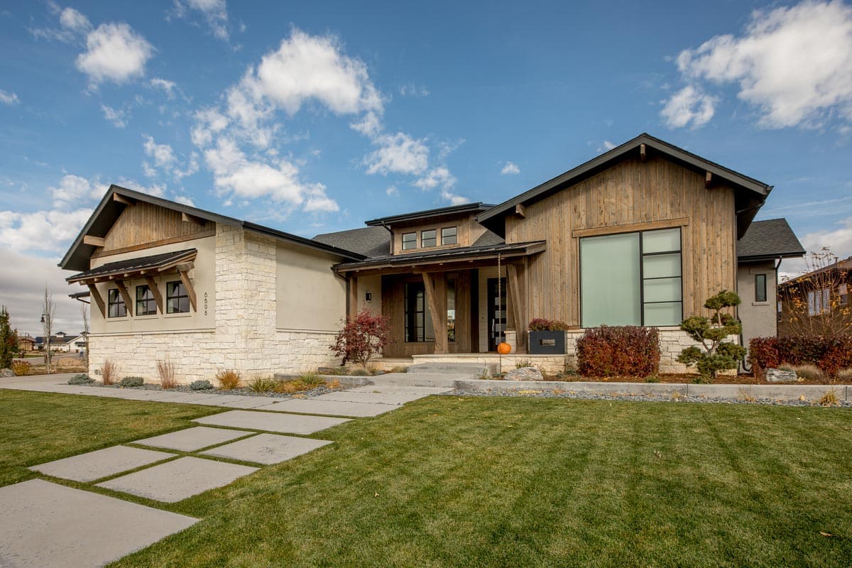 Modern house plan exterior with wood siding, stone accents, covered entry, and large windows.