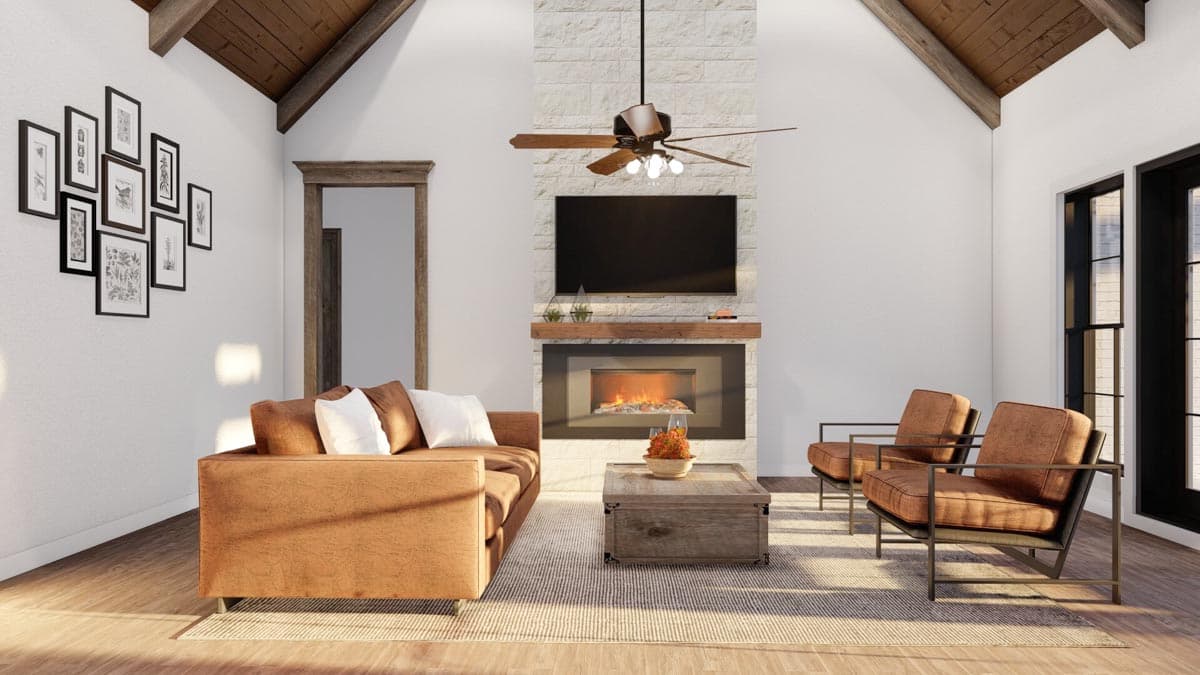 Living room with vaulted wood-beamed ceiling, fireplace, television, sofa, and armchairs.