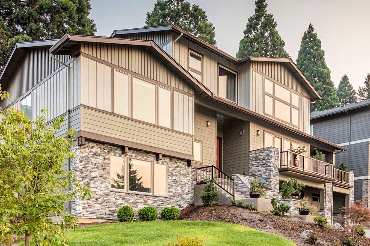 Modern house plan exterior with stone and vertical siding, multiple gables, and large windows.
