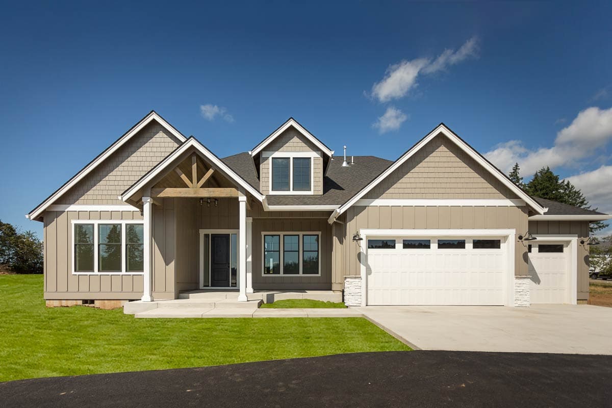 House plan exterior. Ranch style with multiple gables, a covered porch, and a side-entry garage. Features include dormers and shake siding.