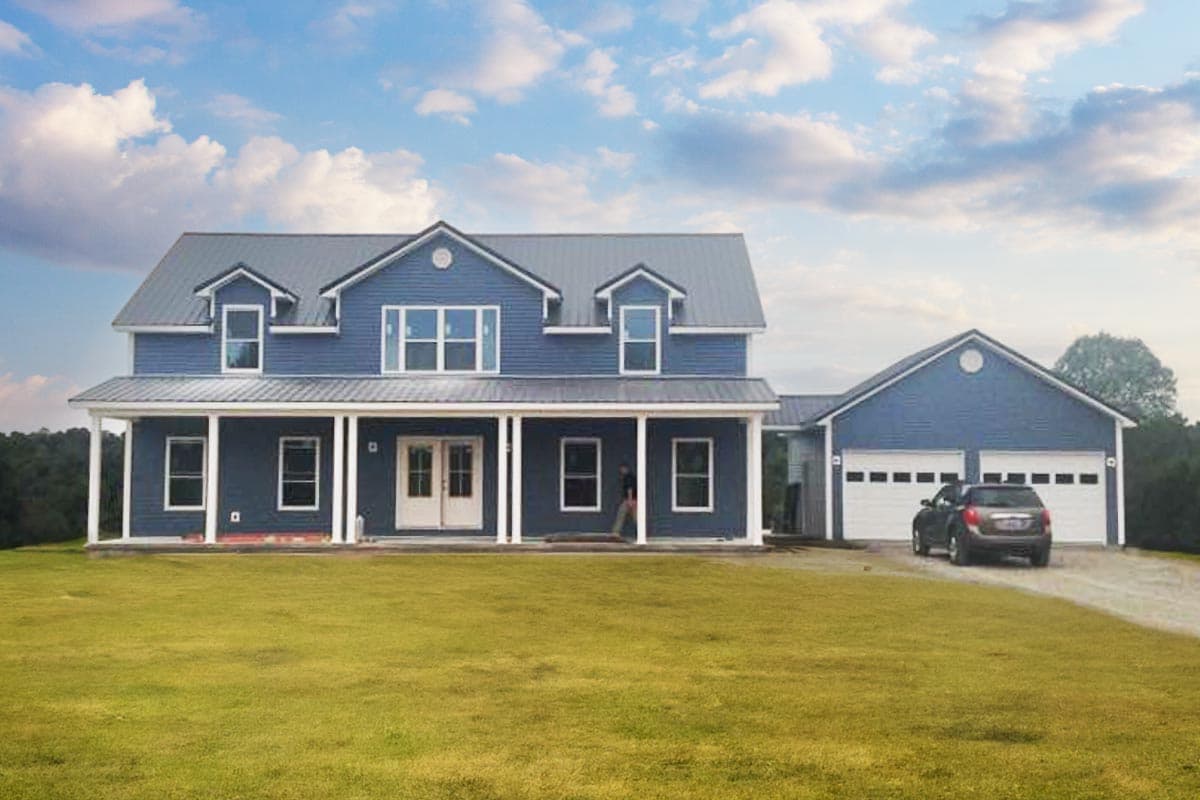 House plan exterior. Two-story with a porch, dormers, and attached garage. Features a metal roof and double-hung windows.
