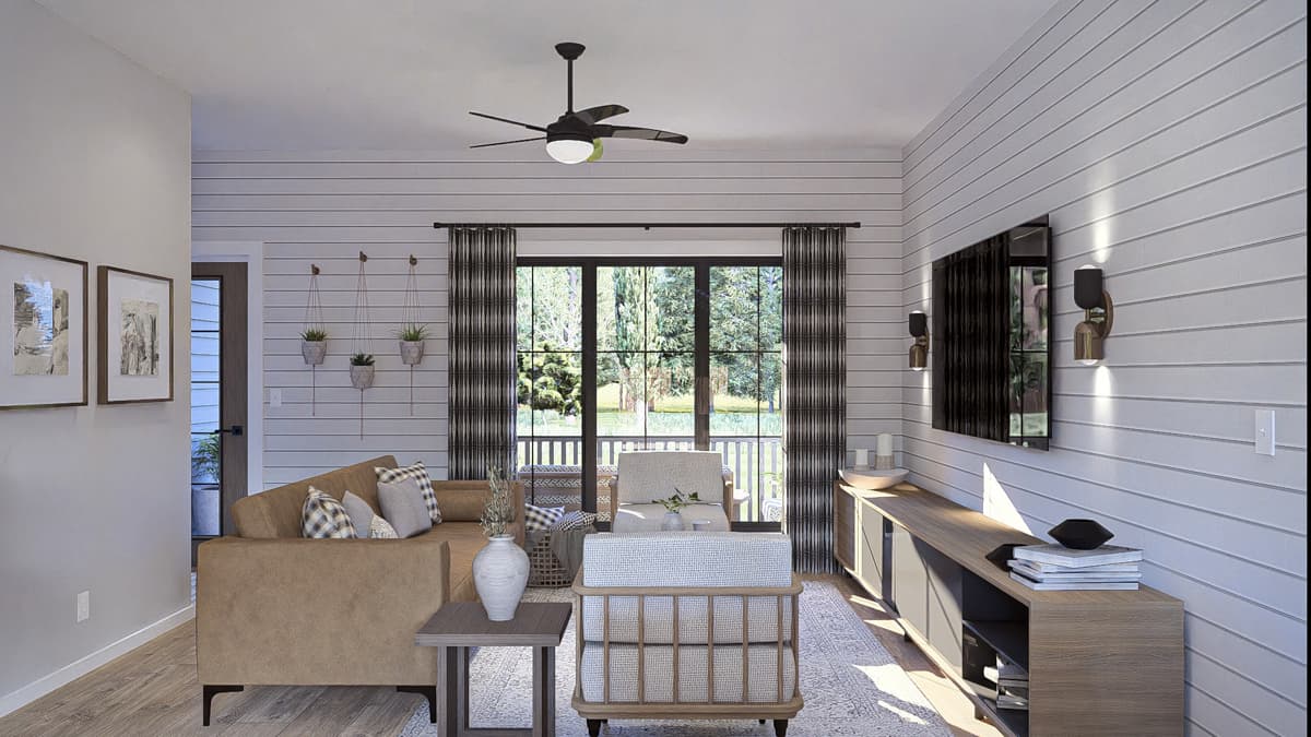 Living room interior with shiplap walls, a sectional sofa, and large glass doors opening to an outdoor space.