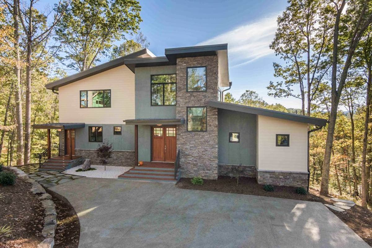 House plan exterior. Two-story, Modern design with a stone veneer accent. Features a shed roof, covered porch, and a mix of horizontal siding.