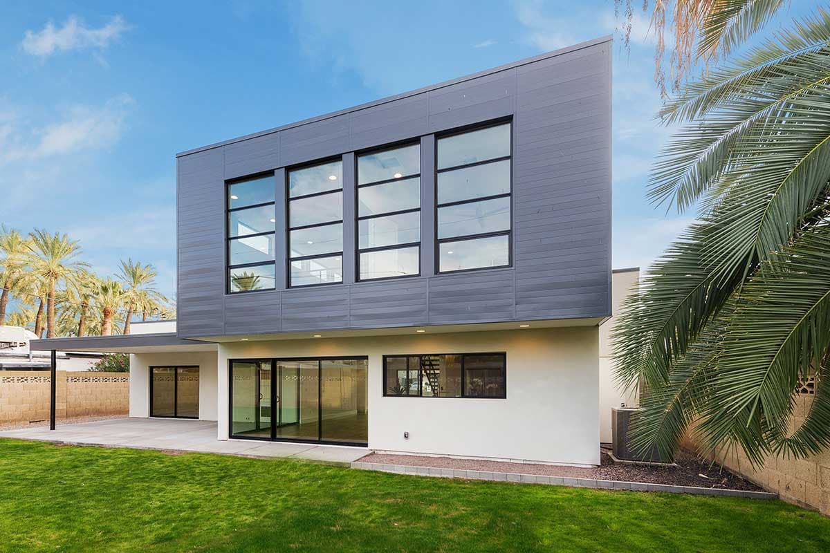 Modern house plan exterior with two stories, large upper-level windows, and glass sliding doors on the lower level.