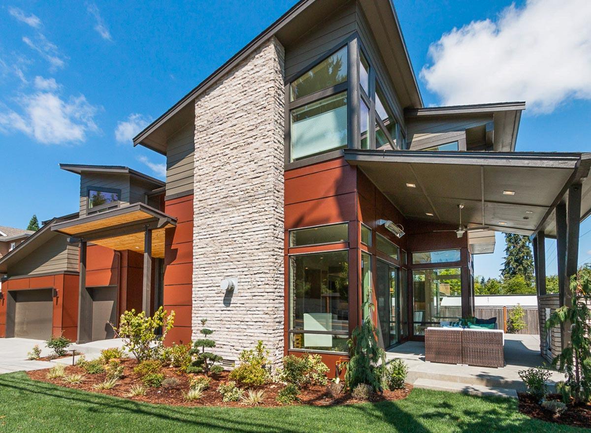 Modern house plan exterior with stacked stone accent, cantilevered roof, and extensive glass.