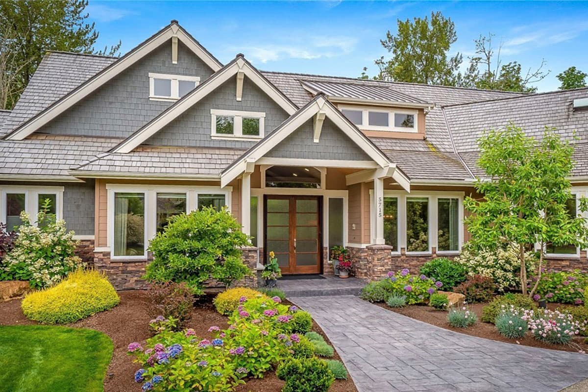 House plan exterior: Craftsman style, multiple gables, stone accents, and covered entry with double doors.