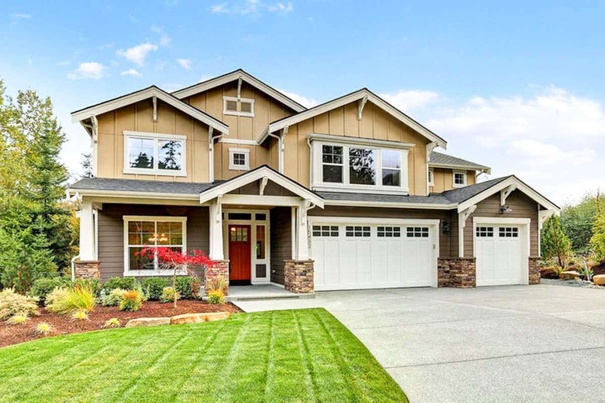 House plan exterior. Two-story Craftsman home with gabled roof, covered porch, and attached garage. Stone accents and multiple dormers are visible.